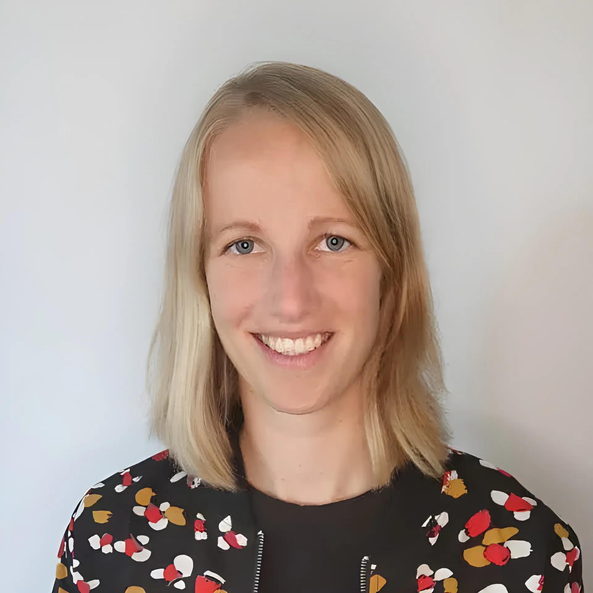 Portrait of a smiling woman with blonde hair.