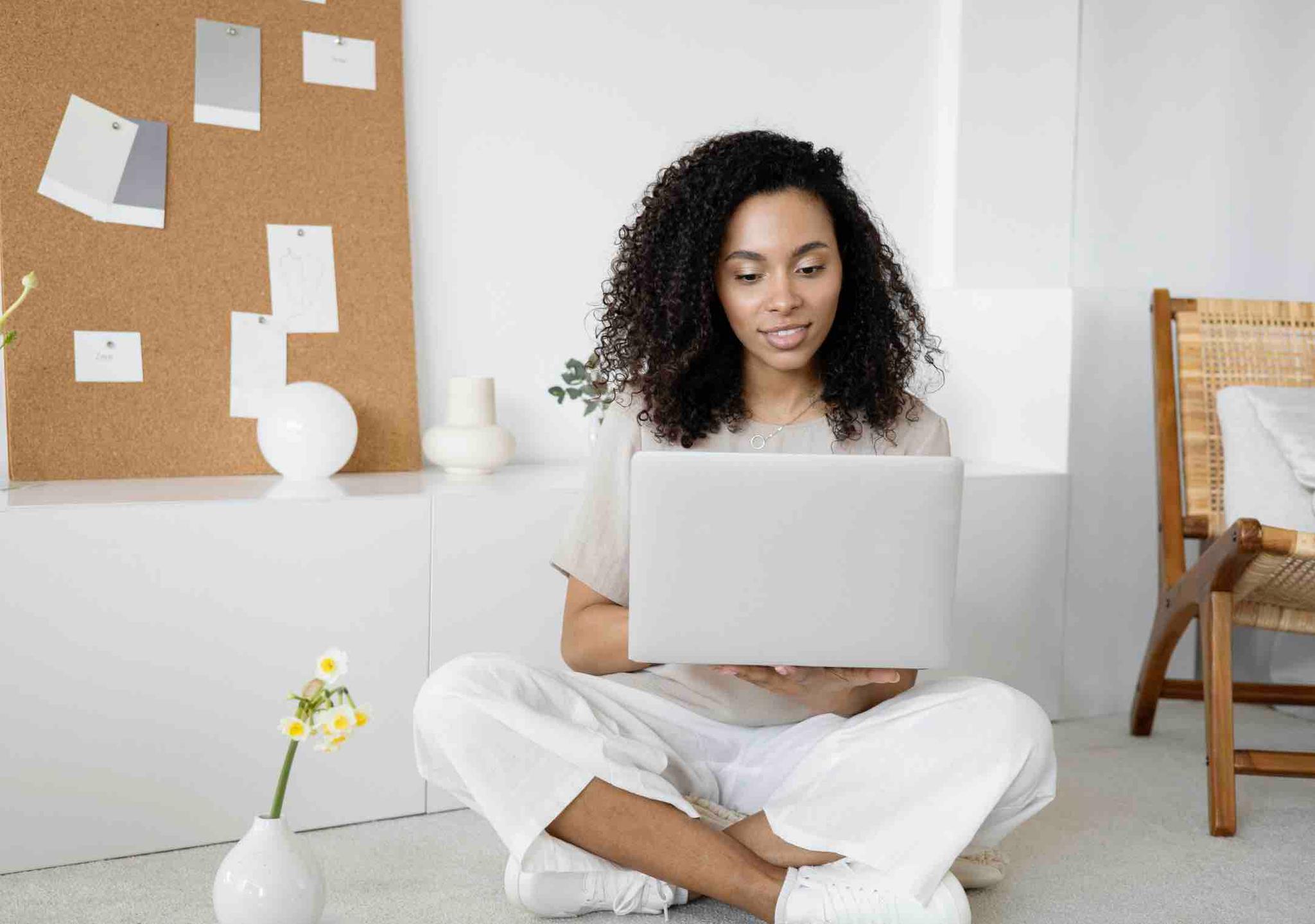 Woman sitting with laptop in bright room