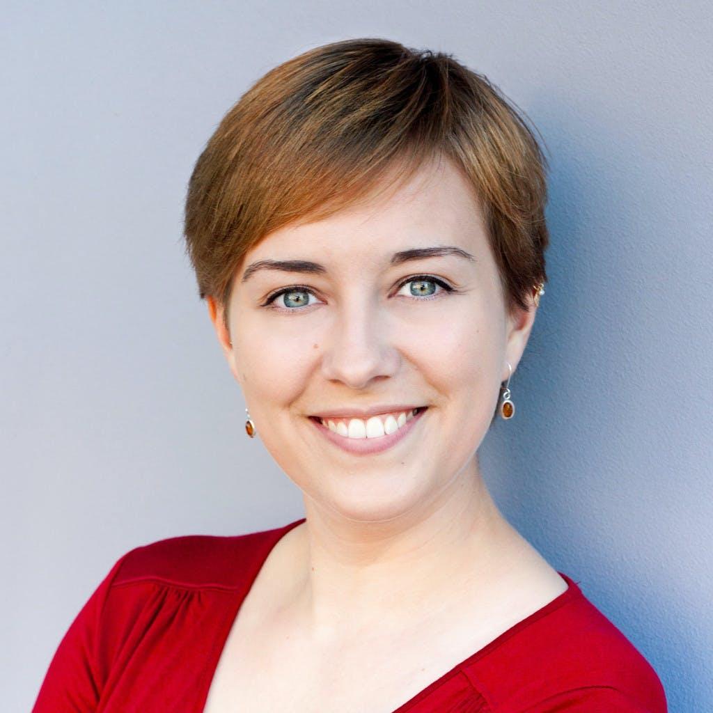 Portrait of a smiling woman with short hair against gray background
