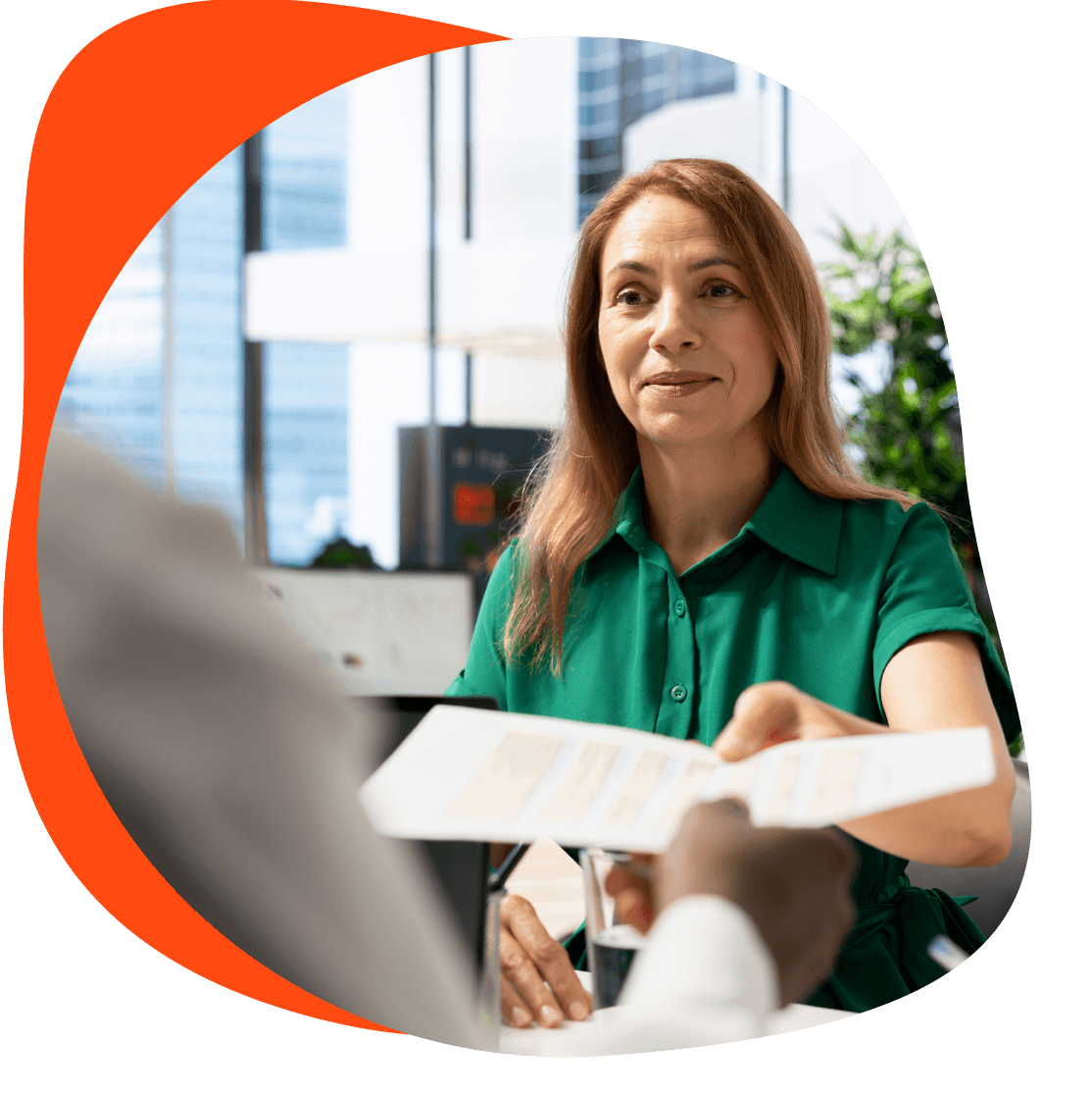 Frau übergibt Dokument in einem Büro.