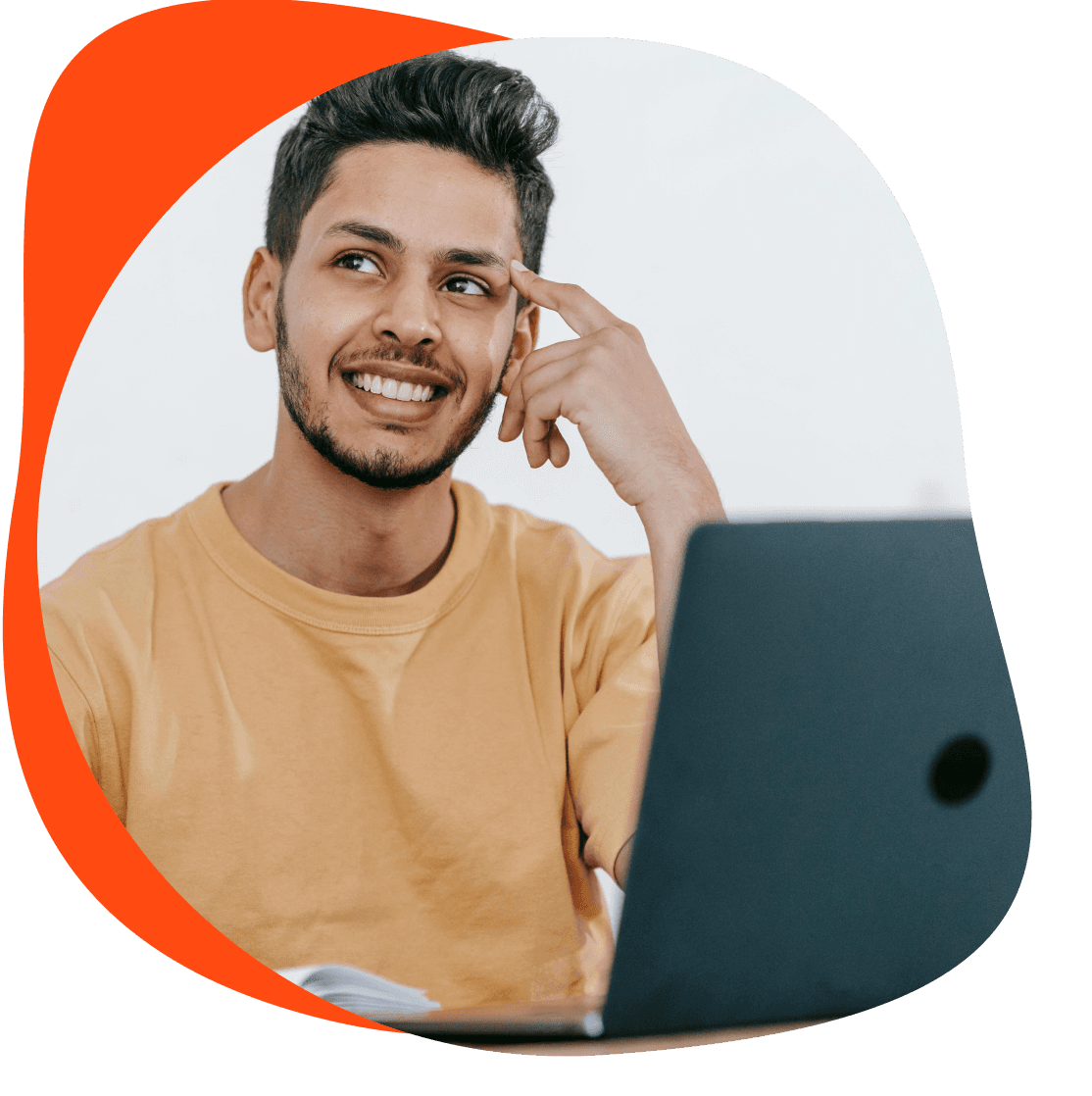 Lächelnder junger Mann sitzt am Laptop.