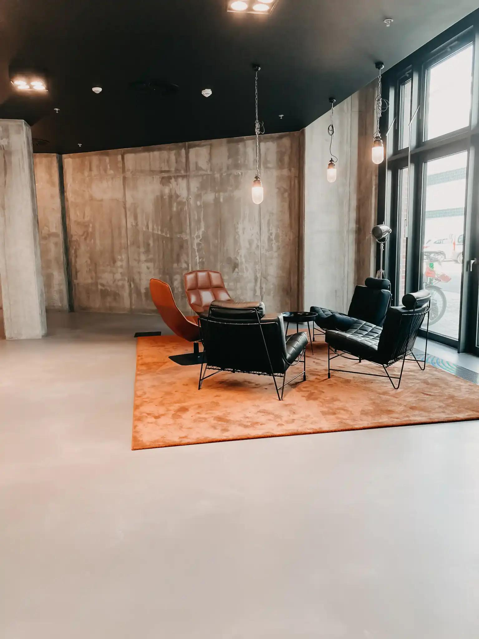 Moderner Warteraum mit Stühlen und Teppich.