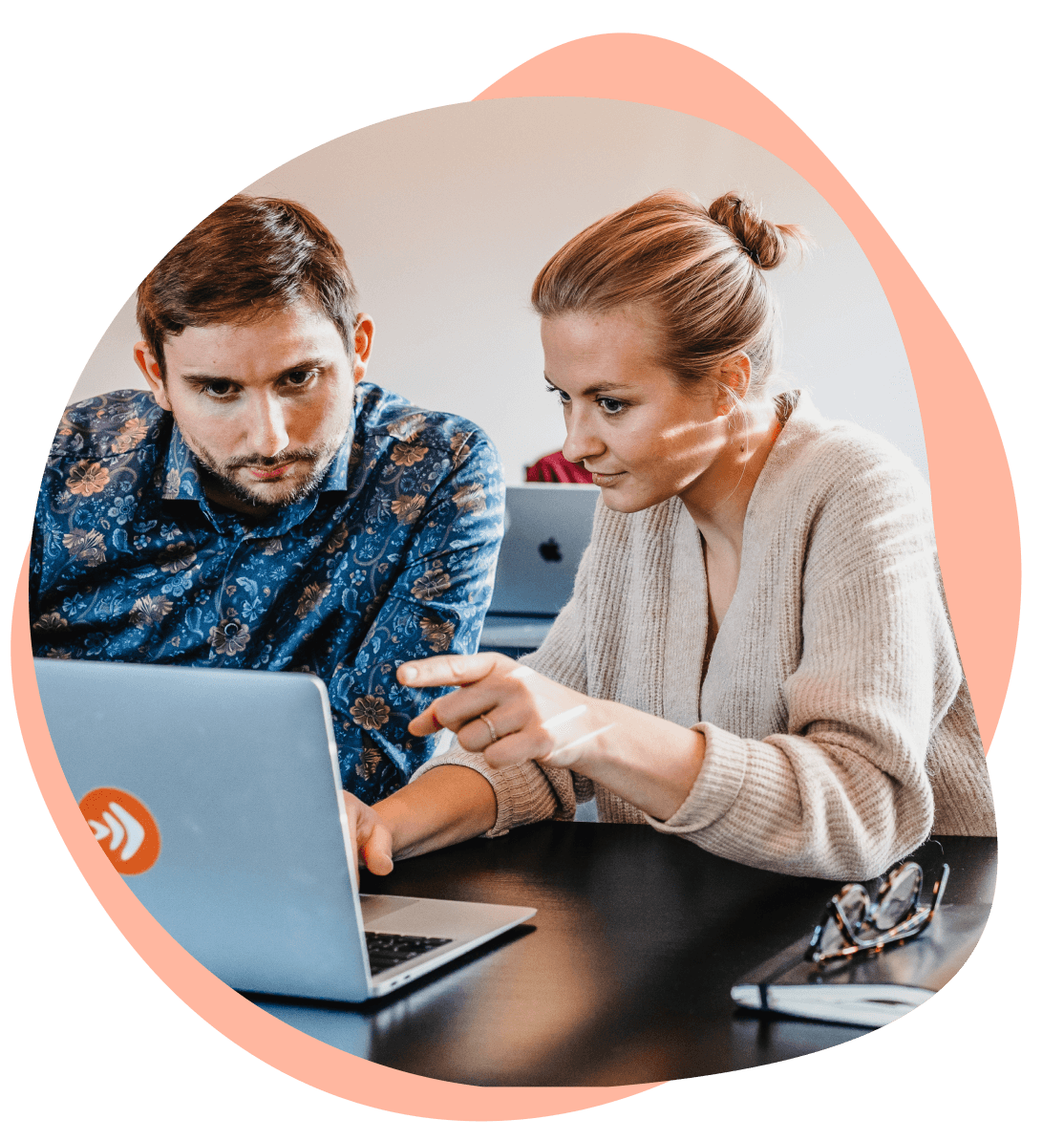 Zwei Personen arbeiten gemeinsam an einem Laptop.