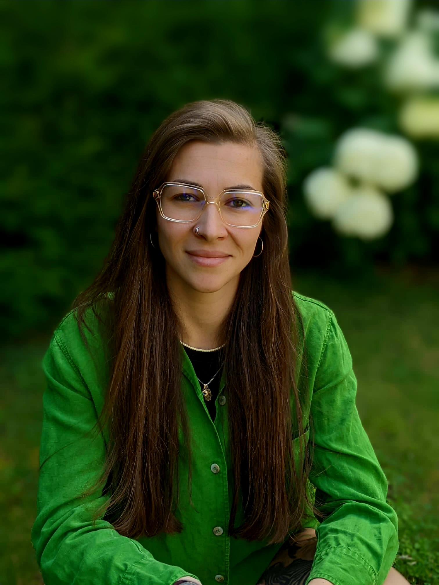 Frau mit Brille und grünem Hemd im Freien