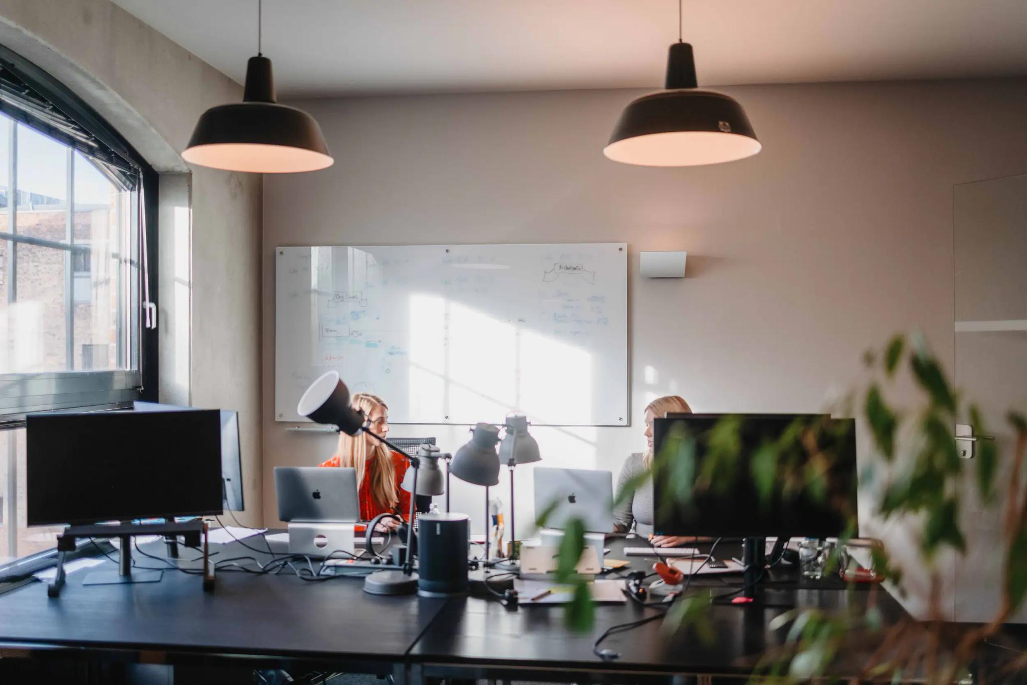Office with computers and person holding a megaphone.