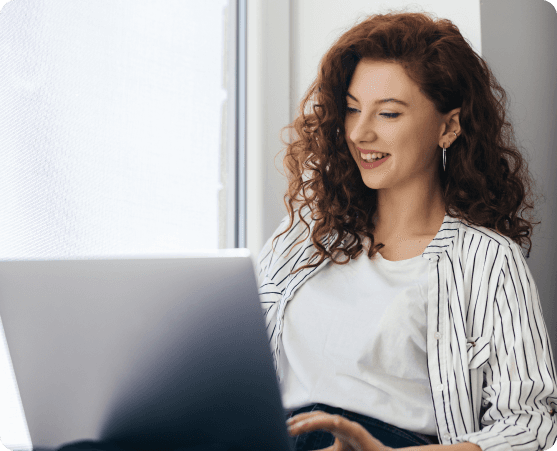 Woman smiling while using a laptop