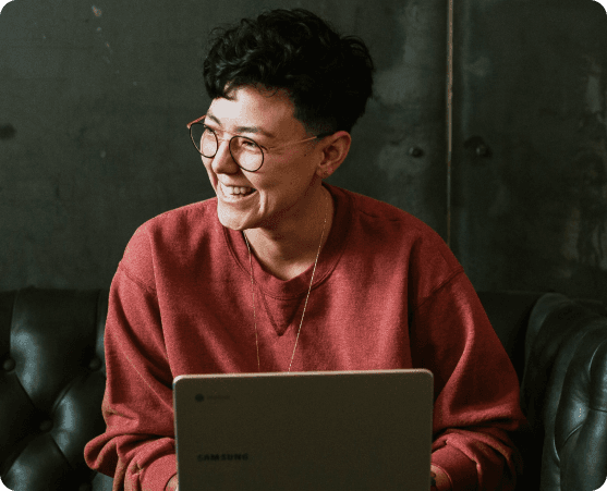 Lächelnde Person mit Brille vor Laptop