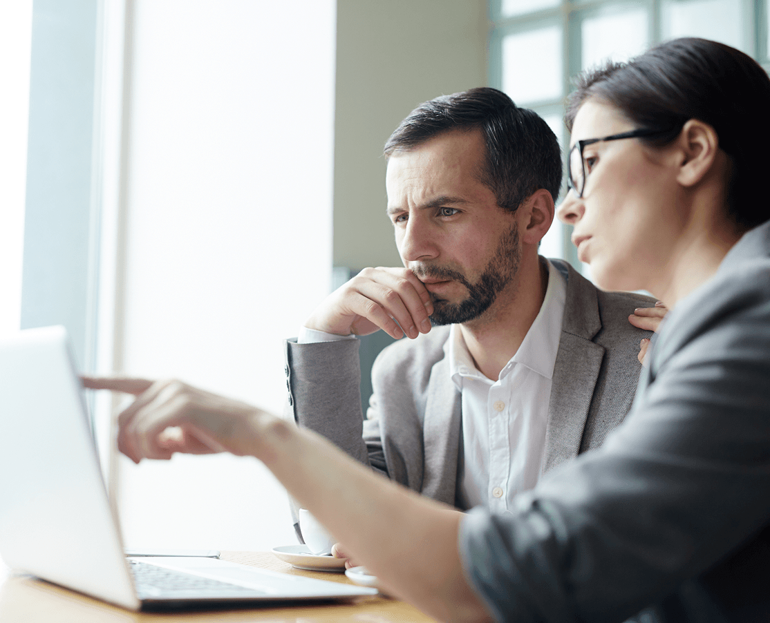 Zwei Personen diskutieren am Laptop.