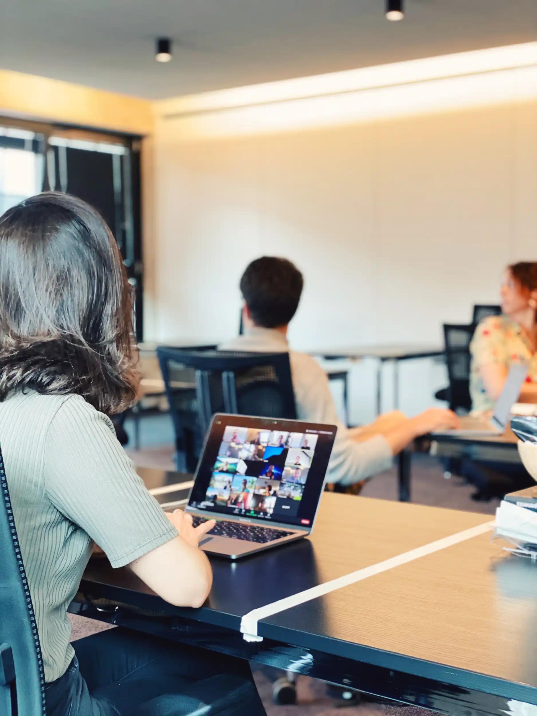 Person, die Laptop mit Videokonferenz in Büro verwendet