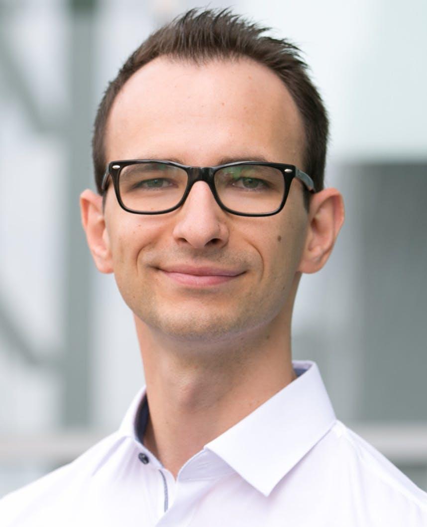 Portrait of a man wearing glasses and a white shirt