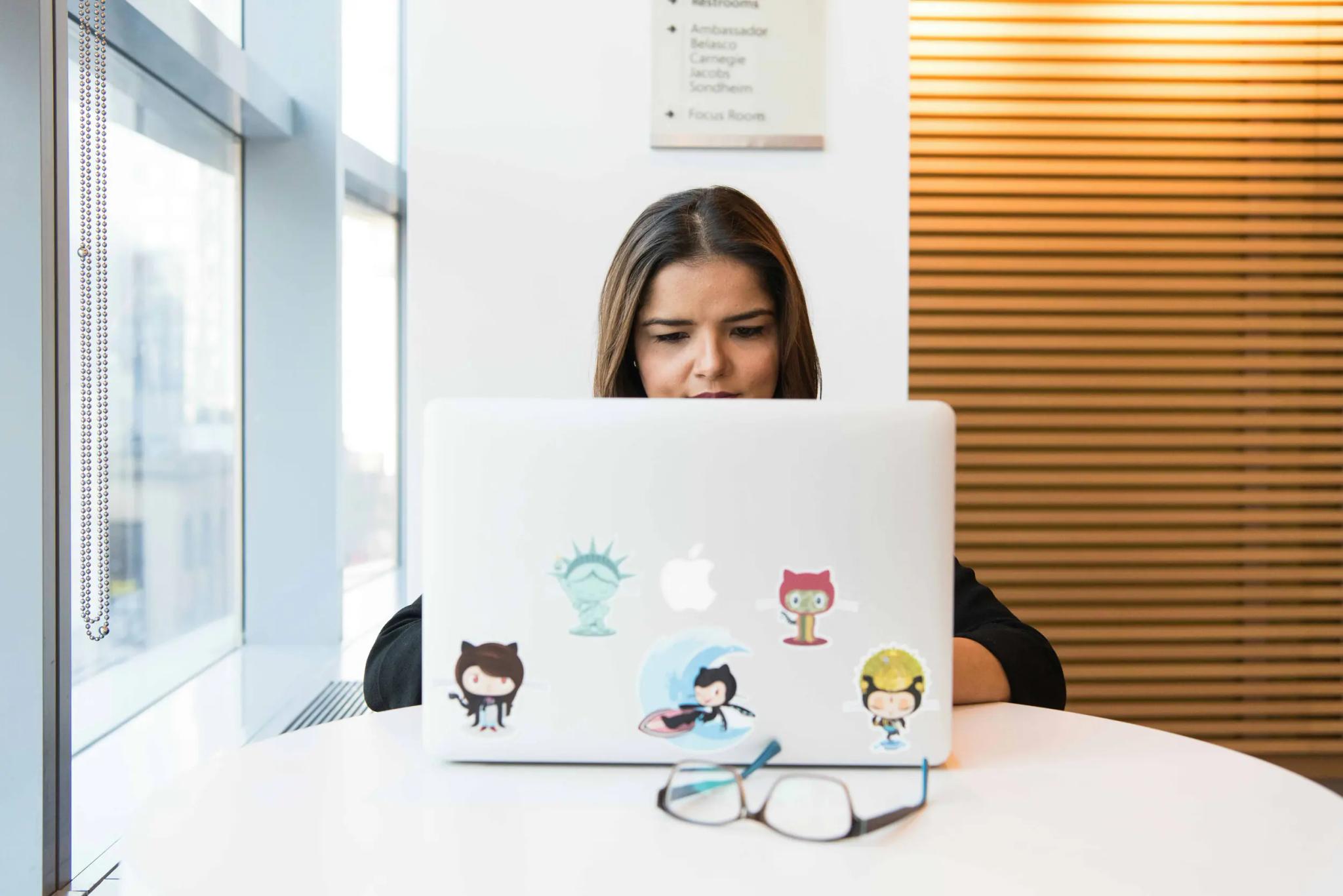 Woman working on laptop in modern office.