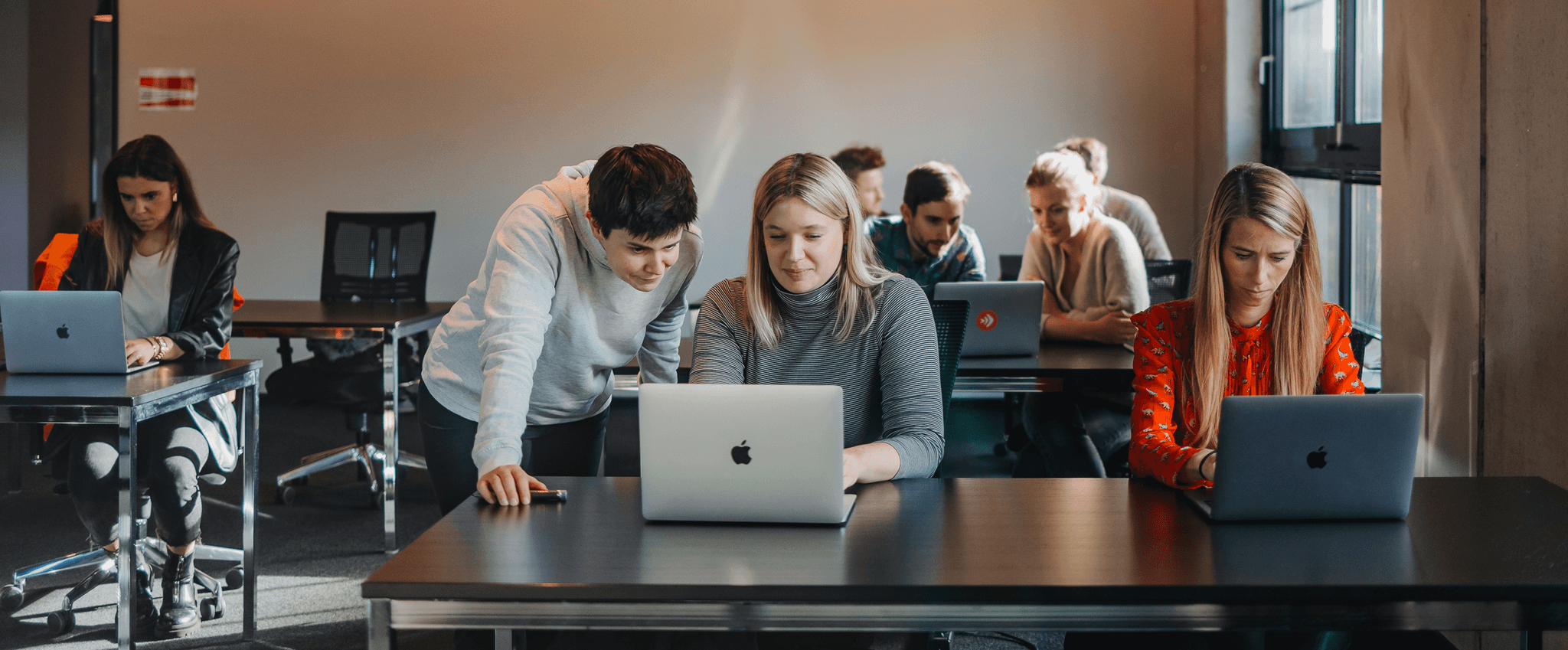 Menschen arbeiten an Laptops in einem Klassenraum